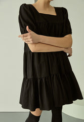 Tiered linen mini dress with square neckline and puff sleeves for effortless elegance