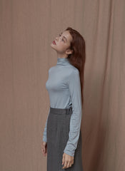 Soft cotton turtleneck top with stretch fit and minimalist tailoring for modern layering