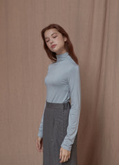 Soft cotton turtleneck top with stretch fit and minimalist tailoring for modern layering