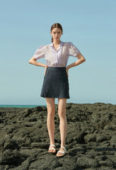 High-waisted linen mini skirt with structured silhouette and textured weave for refined summer style